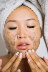 Close-up of a woman gently scrubbing her face with cream