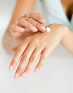 woman applying moisturizer on hand