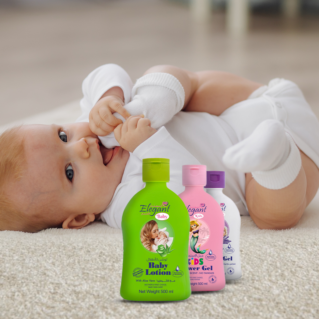 An infant lying on a soft carpet, wearing white clothing and socks, gently holding their foot. In the foreground, four colorful bottles of baby care products—baby lotion and kids’ shower gels—are displayed upright.