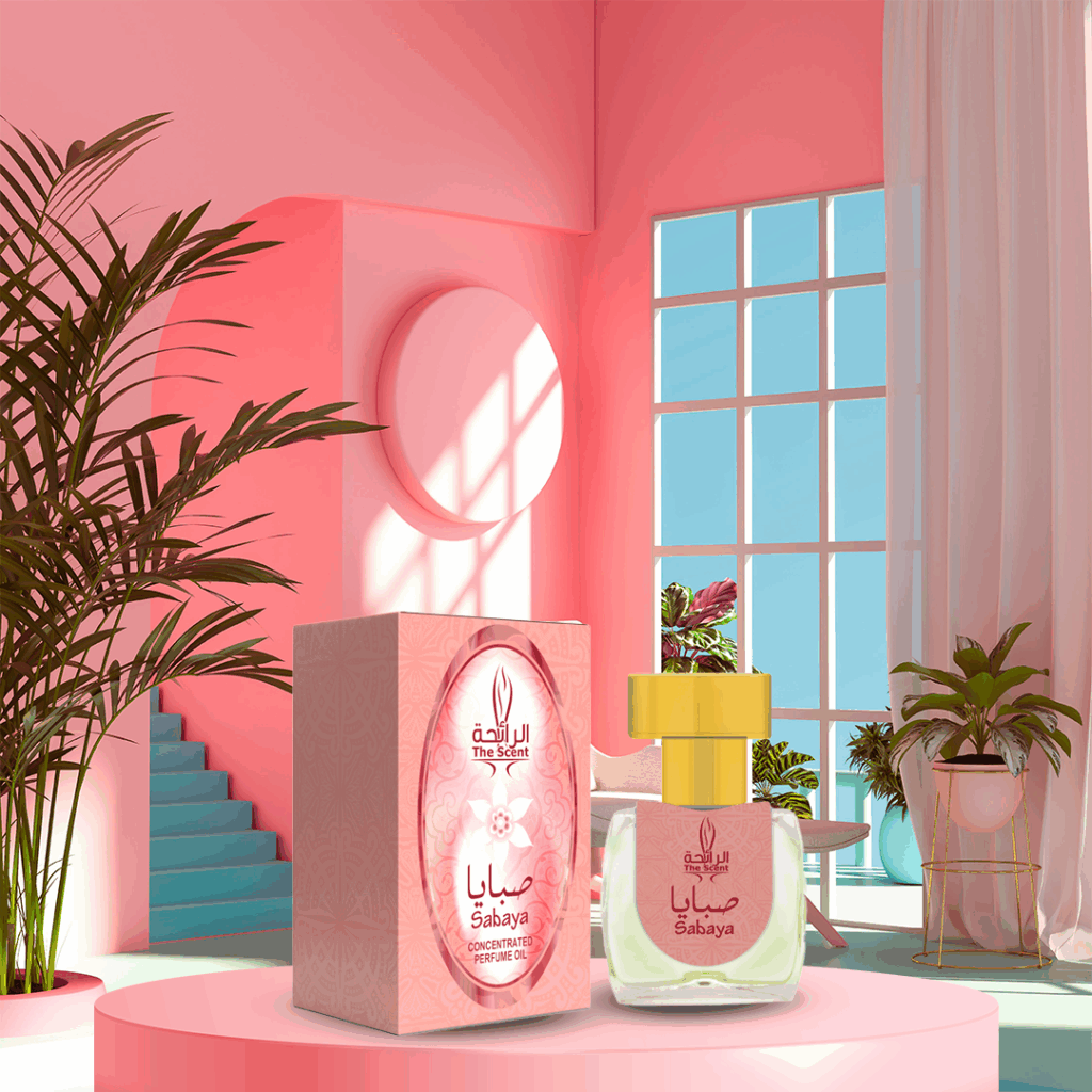 A bottle and box of Sabaya concentrated perfume oil displayed on a round pink surface in a stylish, brightly lit room with pink walls, large windows, plants, and teal steps in the background.