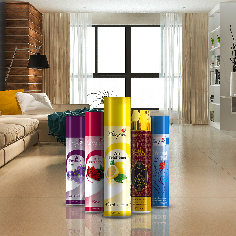 Five colorful air freshener spray cans displayed in the foreground of a modern living room. The cans feature different scents, including lavender, rose, floral lemon, oud, and a blue variant labeled “Elegant Lady,” standing upright on a glossy floor with a bright, stylish interior in the background.